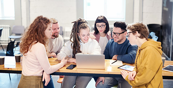 Team building side by side around a laptop